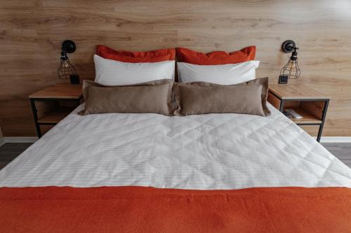 a large bed with three pillows and two tables at Fishel in Odesa