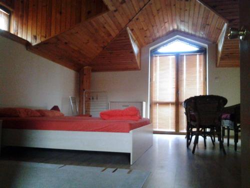 a bedroom with a red bed and a wooden ceiling at Paradise Bay Villas in Sozopol