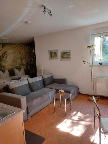 a living room with a couch and a table at Apartment Blütenstadt Werder im Souterraine in Werder