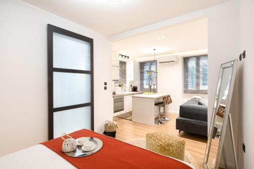 a living room with a dining table and a kitchen at Piccolo Lusso Mini Suite in Corfu Town