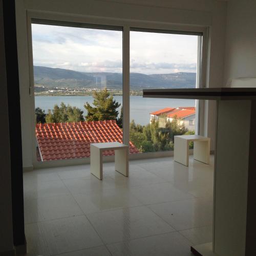 a room with a large window with a view of the water at Apartments Exclusive Palace in Trogir