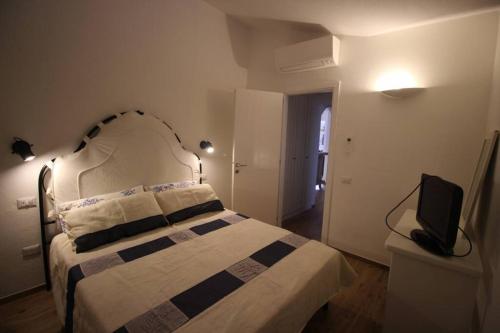 a bedroom with a bed and a television in it at EFFE Apartment Golfo Aranci: Sole, Mare e Relax in Golfo Aranci