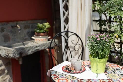 a table with a vase of flowers and two cups at Gipsy Maisonette in Lucca