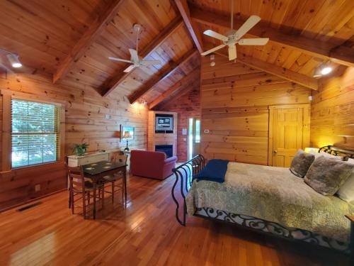 a bedroom in a log cabin with a bed and a desk at New River Trail Cabins in Galax