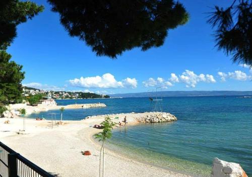 a beach with people on the sand and the water at Rooms & Apartments Toni in Split
