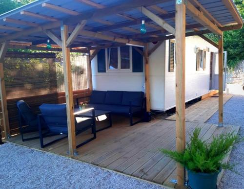 a pergola with a couch and a table on a deck at Lexi Zen House in Kamnik