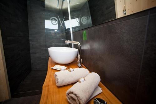 uma casa de banho com um lavatório e uma tigela num balcão de madeira em MAXI SONCE, Odprte vasi em Prvačina
