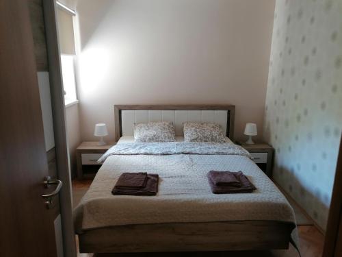 a bedroom with a bed with two night stands and a window at Apartman Bogdanović Sokobanja in Soko Banja