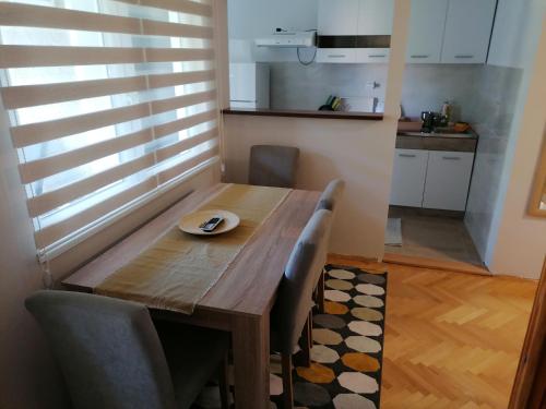 - une table à manger avec des chaises et une plaque de cuisson dans l'établissement Apartman Bogdanović Sokobanja, à Sokobanja