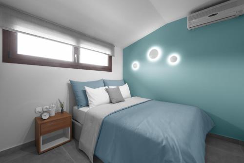 a blue and white bedroom with a bed and a window at Pola's loft in Ierissos