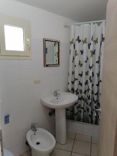 a bathroom with a sink and a toilet and a shower curtain at Campeggio Lao in Scalea