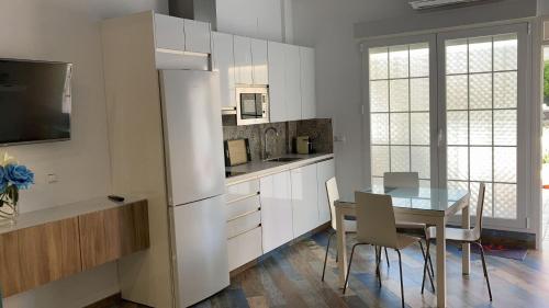 a kitchen with a table and a white refrigerator at Cordoba Tourist Apartments in Córdoba