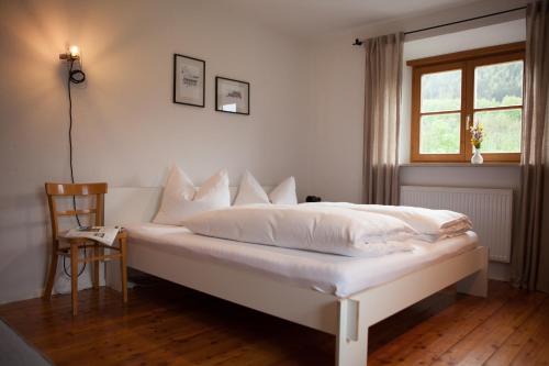 a white bed in a room with a window at ALPENRAUM Ferienwohnungen Berchtesgaden in Berchtesgaden