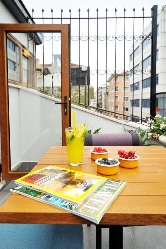 a wooden table with a magazine and a drink on it at Stayso by Cloud7 Hotels in Istanbul
