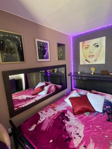 - 2 lits dans une chambre avec éclairage violet dans l'établissement Purple Secret Naturiste, au Cap d'Agde