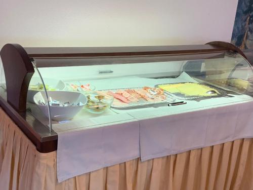 a glass display case with food on a table at Hotel Schneeberger in Niederau