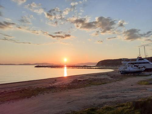 a sunset on a beach with boats on the shore at Pola's loft in Ierissos