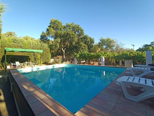 una piscina con 2 sillas y una mesa en Alojamientos Cabezo del Gato, en Aracena