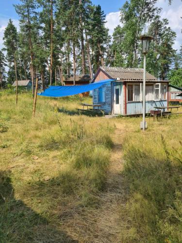 a small house with a blue tarp in a field at База відпочинку Енергія in Rudnya Peskovskaya
