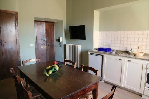 a kitchen with a table with a bowl of fruit on it at Corte Fratini Appartamenti in Trevi