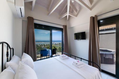 um quarto com uma cama e uma grande janela em Voula Villa Luxury em Lefkada