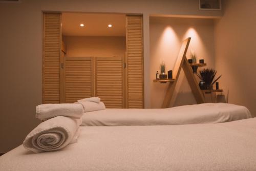 a bedroom with two beds with white towels on them at Hôtel 1770 & Spa in Le Pontet