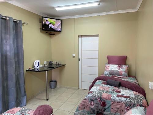 a bedroom with a bed and a tv on the wall at 4 on Sirius in Polokwane