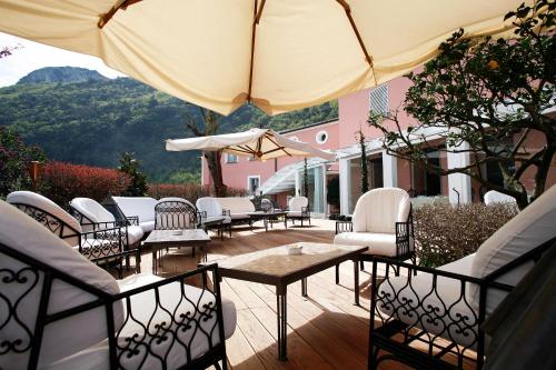 a patio with tables and chairs and an umbrella at La Locanda Delle Donne Monache in Maratea