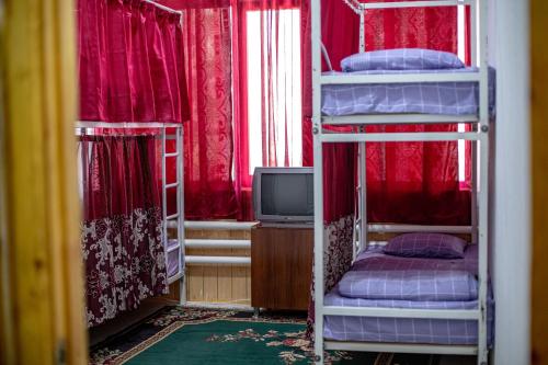 a room with three bunk beds and a television at HOSTEL NABI BOBO in Samarkand