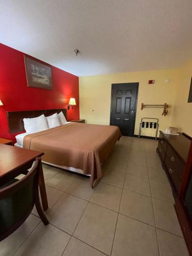 een hotelkamer met een bed en een rode muur bij Relax Inn McRae in McRae
