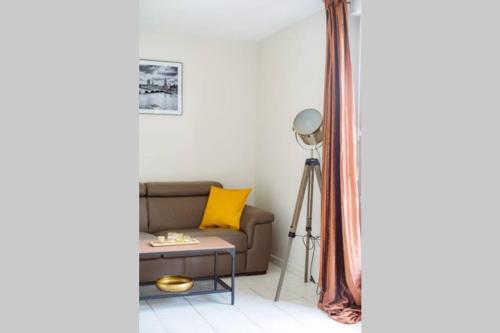 a living room with a couch and a table at Le Lumineux-T2-43m2-Face Val d'Europe-Disney in Montévrain