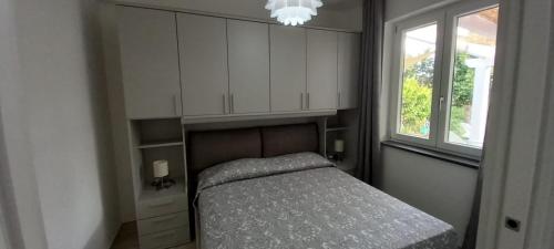 niewielka sypialnia z łóżkiem i oknem w obiekcie Casetta Furiana w mieście Procida