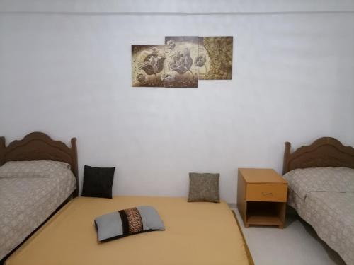 1 Schlafzimmer mit 2 Betten und einem Tisch mit Kissen in der Unterkunft Hergla_AFH_Beach in Harqalah