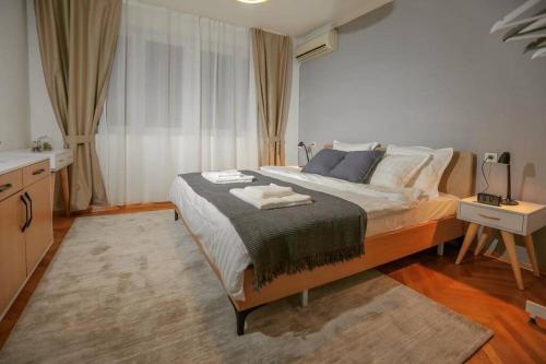 a bedroom with a large bed and a table at Mickitos Apartments at Macedonia Square in Skopje