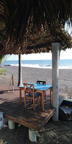a table and chairs on a wooden deck on the beach at Dulce y Salado in La Curbina