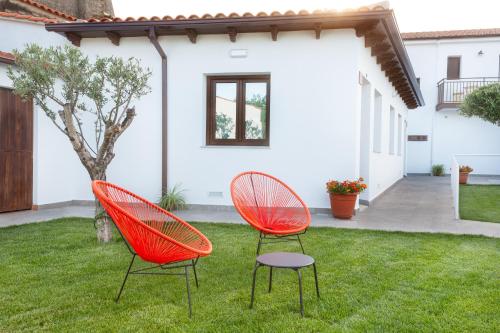 two orange chairs sitting in the grass in a yard at Apartamentos Rurales Cielo de Monfragüe in Malpartida de Plasencia