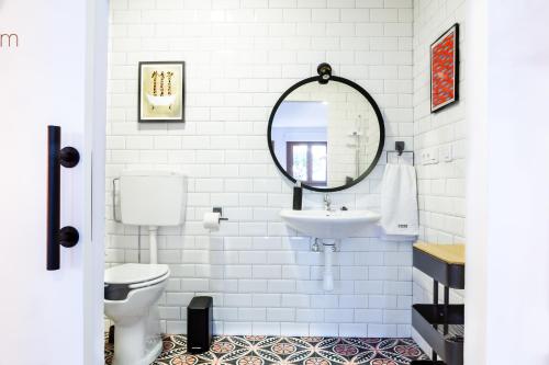 a white bathroom with a sink and a mirror at Apartamentos Rurales Cielo de Monfragüe in Malpartida de Plasencia