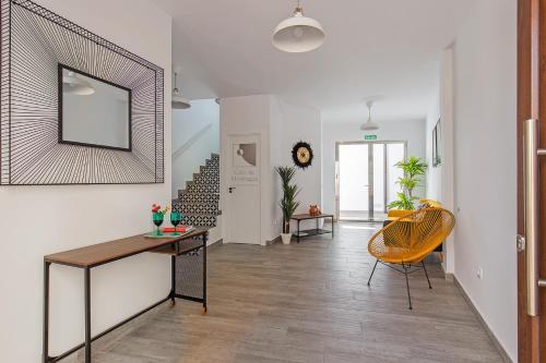 a hallway with a table and a mirror on a wall at Apartamentos Rurales Cielo de Monfragüe in Malpartida de Plasencia