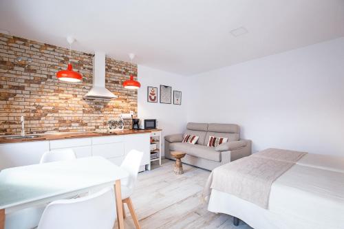 a kitchen and living room with a bed and a table at Apartamentos Rurales Cielo de Monfragüe in Malpartida de Plasencia