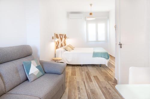 a living room with a couch and a bed at Apartamentos Rurales Cielo de Monfragüe in Malpartida de Plasencia