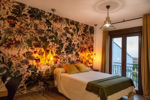 a bedroom with a bed and a floral wall at Apartamentos Rurales Cielo de Monfragüe in Malpartida de Plasencia