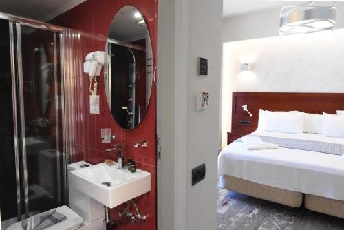 a bathroom with a bed and a sink and a mirror at Viaros Hotel Apartments in Tolo