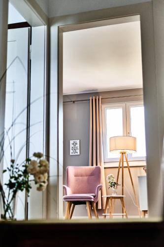 a living room with a pink chair and a lamp at PRIMERA Villa in Singen
