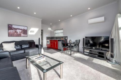 a living room with a couch and a tv and a table at TWO FOUR COLOGNE in Martinborough 