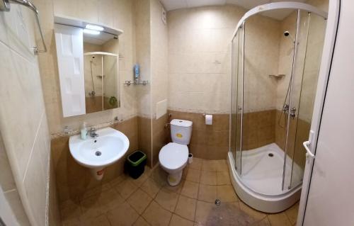 a bathroom with a toilet and a sink and a shower at Pomorie Beach Resort in Pomorie