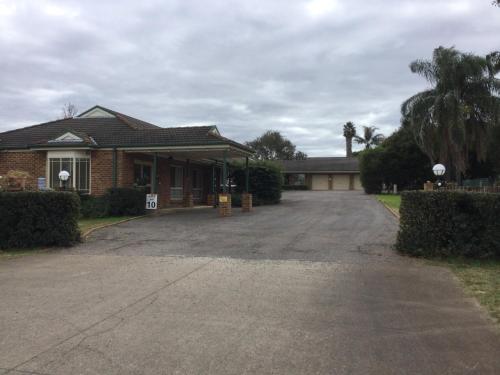 a house with a driveway in front of it at Aberdeen Motel in Aberdeen