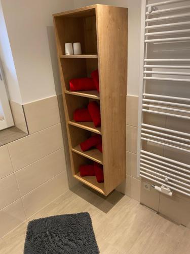 a wooden closet with red pillows in a bathroom at Appartement Bär in Eben im Pongau