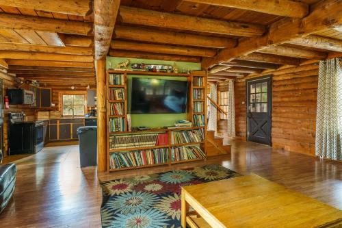 a living room with a television and bookshelves at Mountain Trail Lodge and Vacation Rentals in Oakhurst