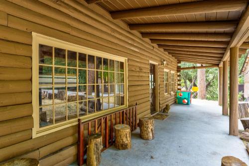 a porch of a wooden house with a window at Mountain Trail Lodge and Vacation Rentals in Oakhurst