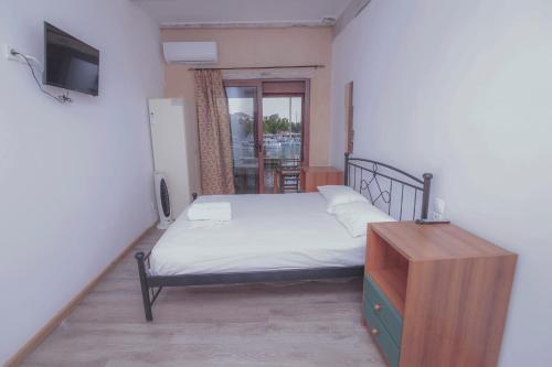 a bedroom with a bed and a dresser and a television at Orfeas Studios in Vasiliki